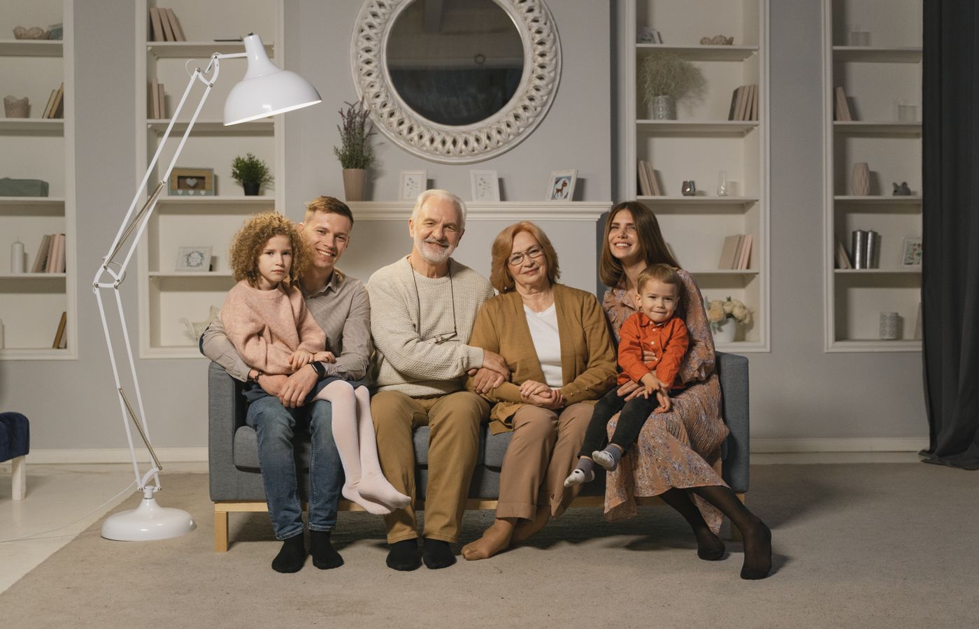A multigenerational family spending time together in a warm living room.
